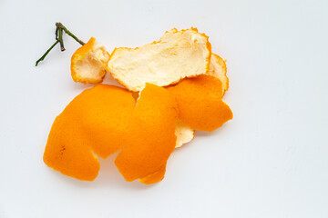 Bright orange tangerine peel with a green stem, isolated on a clean white background.