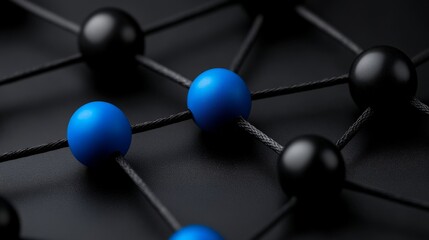 Interconnectedness: Abstract image of black and blue spheres linked by thin black cords, creating a network pattern against a dark background.  This symbolizes connection, collaboration.
