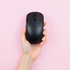 A hand holding a sleek black computer mouse on a vibrant pink background. Perfect for tech, office, and minimalist design themes.