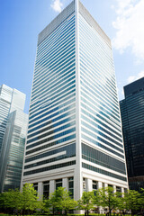 A tall building with a lot of windows and a green tree in front of it