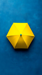 Yellow umbrella, blue background, overhead shot