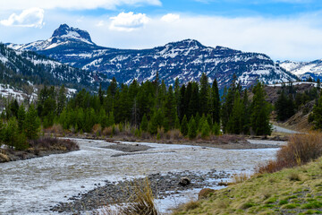 Mountain river with muddy water, melting snow in the mountains. Mountain landscape, Montana