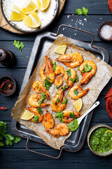  Fried shrimps with lemon and green on a metal tray vertical photo