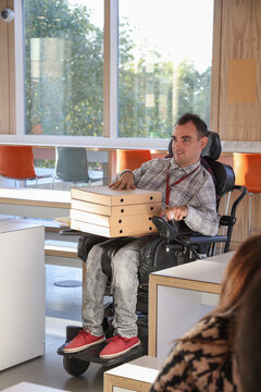 Man in wheelchair with stack of pizza box