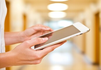 Happy woman doctor using a tablet to manage employees, streamline hospital workflows, and offer solutions for hospital staff through software or an app. Healthcare manager leveraging digital