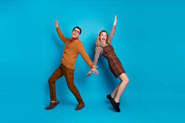 Young couple posing with joyful expressions against a vivid blue background