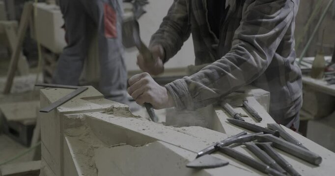 stonemason chiseling and working on part of gothic cathedral