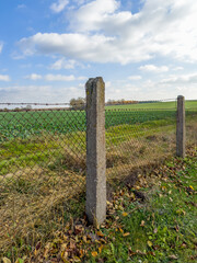 stare ogrodzenie wykonane z betonowych solidnych słupów i stalowej siatki.  © Kamil_k2p