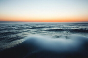 Obraz premium Sunset over calm ocean waters creates a serene atmosphere with vibrant colors on the horizon