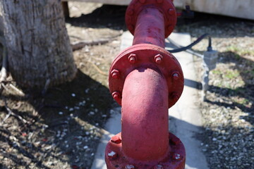 Weathered old metal pipe for utility supply painted red