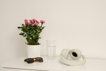 A stylish minimalist setup with headphones, sunglasses, and fresh flowers for your workspace