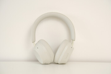 Stylish White Wireless Headphones Positioned on a Beautifully Minimalist Background Scene © Di_Ilikaeva