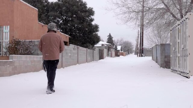 Man Walking Down Urban Alley in a Snow Storm
