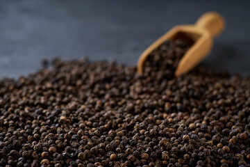 black pepper seeds on a black stone table, selective focus.