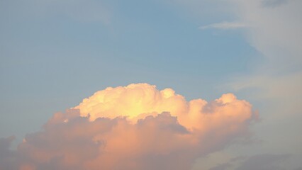 Golden Hour Cumulus Cloud Formation in a Pale Blue Sky