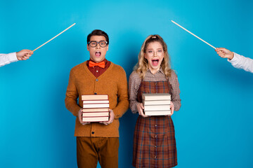 Young couple holding books in a humorous scene with retro clothing and blue background