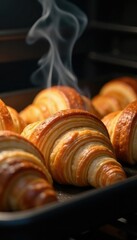 Steam rising from a hot tray of freshly baked ham and cheese croissants, breakfast pastry, oven