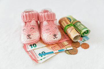Demographic issues. Money, pregnancy test, baby clothes on white background, IVF price, government child benefits, health insurance, increasing birth rate
