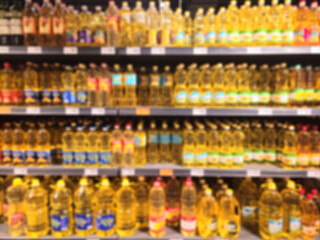 Blurred supermarket shelves stacked with various brands of sunflower oil, creating a vibrant display of consumer choices and product availability. Grocery shop, healthy products, organic, vitamins