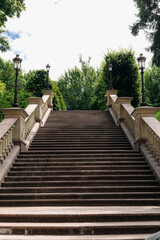 Stone staircase stretching upwards, flanked by ornate balustrades and antique street lamps, leading...