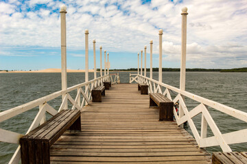 Fototapeta premium Wooden pier, with benches and handrails, in the background the blue sky, in the city of Camucim CE, northeast of Brazil