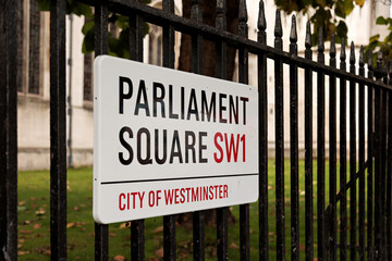 Parliament Square street sign in London on a black iron railing fence.