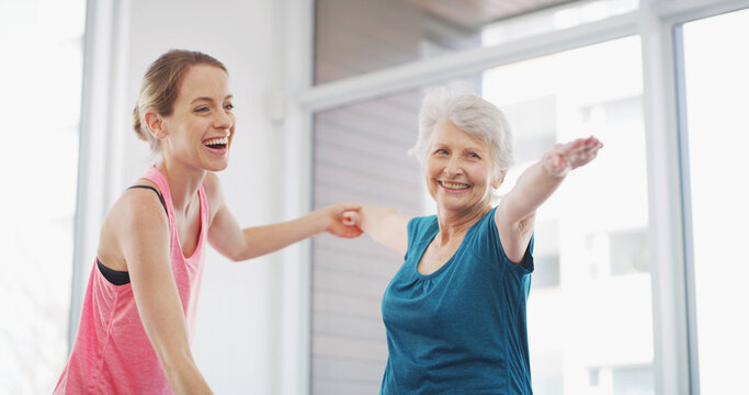Yoga, senior woman and happy coach for fitness, healthy body or warrior pose for geriatric wellness. Stretching, pilates trainer and exercise together for physical therapy, help and laughing in gym