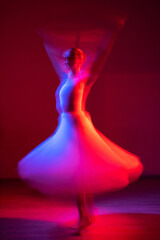 Caucasian woman dancing classical dance in tutu . Long exposure photo. 