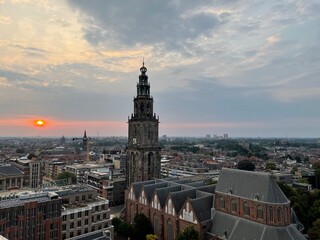 Obraz premium The Martinitoren in Groningen, viewed from the Forum, bathed in the warm glow of a stunning sunset