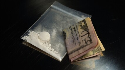 Crushed oxycodone or Heroin maid of opioid medications placed in small plastic container. Become powdered illegal drug stored for sale at clubs, party and streets, indicating substance abuse.