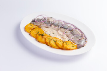 Potatoes and salted herring in a plate.