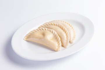 Large dumplings in a plate. On a light background.