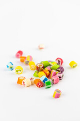 on white background in a small multi-colored sugar caramels with different flavors and patterns lie children's favorite sweets a large selection risk of caries blood sugar excess weight
