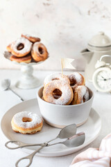 Traditional breakfast of a doughnut with sugar and milk or coffee on a white background. Selective focus.