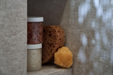 Body care products (scrubs and a natural washcloth) on the shower shelf.
