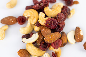 closeup white background a pile of different kinds of nuts is poured healthy food lots of amino acids and antioxidants omega healthy fats in nuts almond pit cashew walnut red cranberry