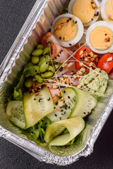 Healthy breakfast consisting of boiled eggs, slices of ham, tomatoes, green beans, aioli sauce