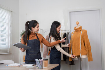 Fototapeta premium Fashion designers discussing design details while presenting a cozy sweater on a mannequin