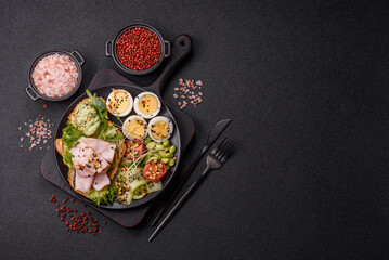 Healthy breakfast consisting of boiled eggs, slices of ham, tomatoes, green beans, aioli sauce