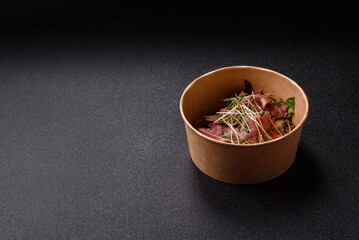 Warm salad consisting of slices of roast beef, greens, tomatoes, cucumbers, green beans