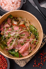 Warm salad consisting of slices of roast beef, greens, tomatoes, cucumbers, green beans