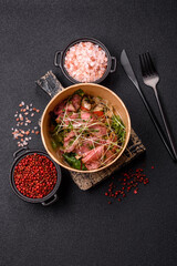 Warm salad consisting of slices of roast beef, greens, tomatoes, cucumbers, green beans