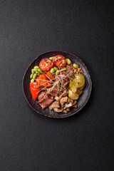 Warm salad consisting of slices of roast beef, greens, tomatoes, cucumbers, green beans