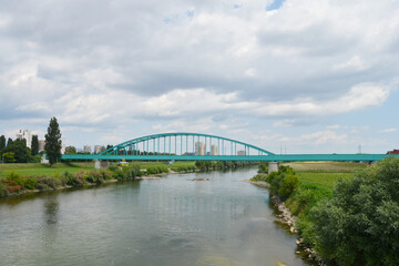 Naklejka premium A scenic view of the Green Railway Bridge, also known as Hendrix Bridge, spans the Sava River in Zagreb, Croatia, under a partly cloudy sky