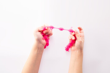 Hand squeeze pink stress ball on white background. Positive thinking concept. Copy space