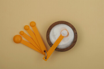 Gluconolactone in wooden plate with measuring spoons. Glucono Delta-Lactone, Pure GDL. White...