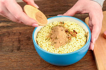 Sprinkling instant noodles with a mixture of pepper and salt.