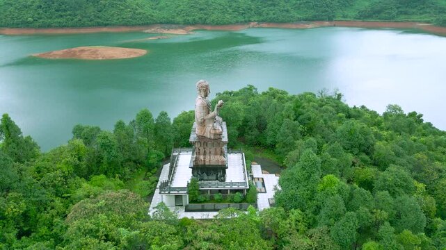 Aerial view on Buddha statue at Bach Ma Zen Monastery, surrounded by lush greenery and serene waters pond in Da Nang.