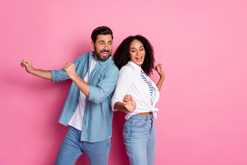 Fototapeta premium Two happy young people enjoying a funny moment against a pink background