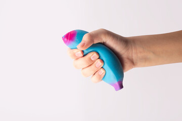 Child hand squeeze blue stress ball on white background. Positive thinking concept. Copy space